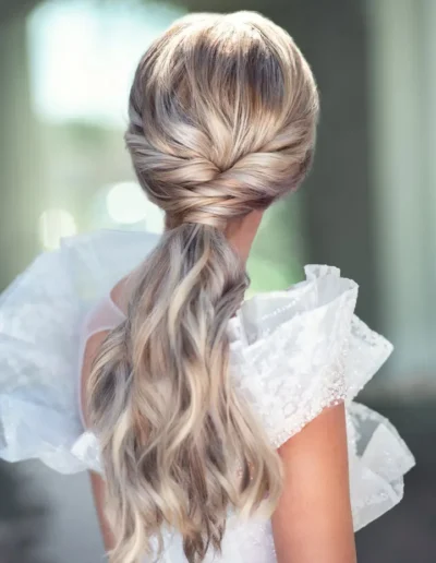 Blonde bridal ponytail with twisted sides and soft waves