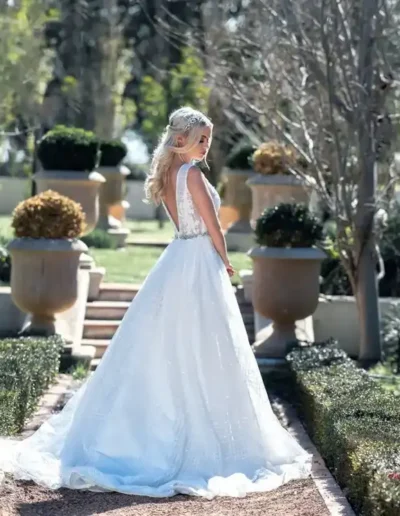 Blonde bride in a white wedding gown photographed in a formal garden