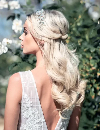 Blonde half-up bridal hairstyle with soft curls and crystal hairpiece