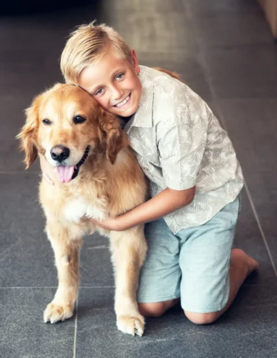 Smiling boy hugging a golden retriever during a portrait photoshoot