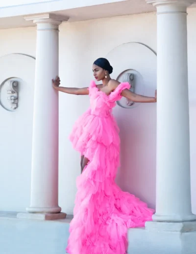 Bride in a long lace wedding gown standing beside a wooden doorway