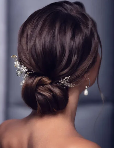 Brunette bridal low bun with delicate floral hairpins