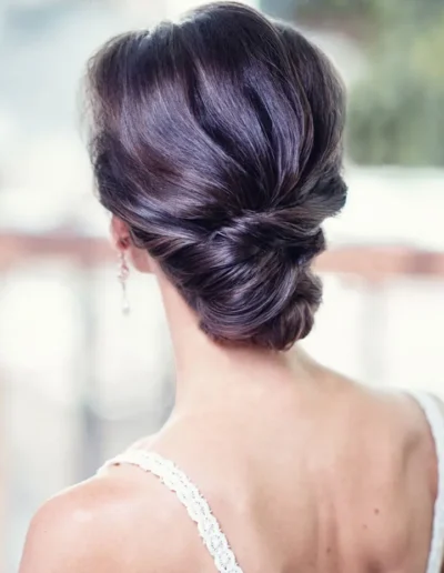 Brunette bridal hairstyle with elegant twisted low updo