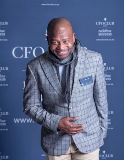 Businessman in a checked blazer photographed at a corporate event