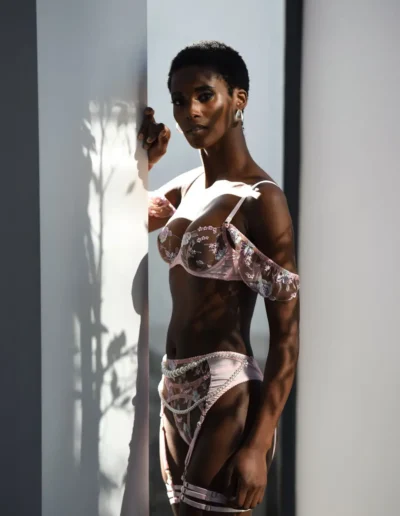 Woman in floral lingerie posing in dramatic sunlight