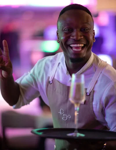 Smiling hospitality staff member serving guests at a Cape Town event