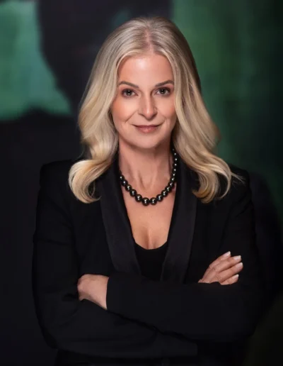 Professional woman in a black suit posing for an executive headshot