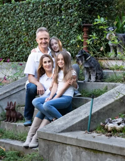 Family with two daughters and dogs posing together in a garden