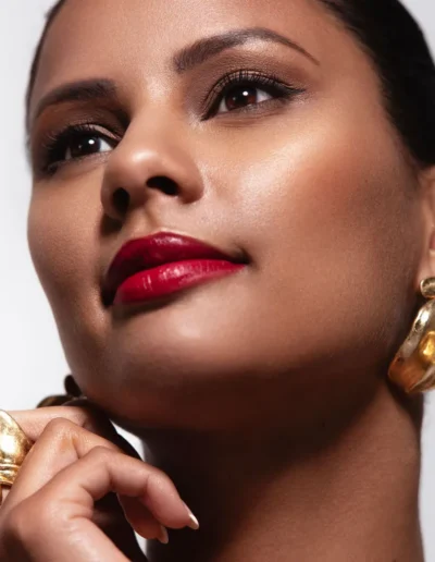 Glamour makeup with smokey eyes, glossy red lips and gold accessories