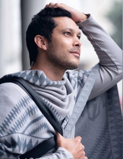 Male lifestyle portrait wearing a patterned grey sweater outdoors