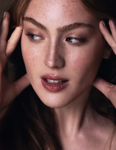 Natural makeup with visible freckles, soft eyes and glossy lips