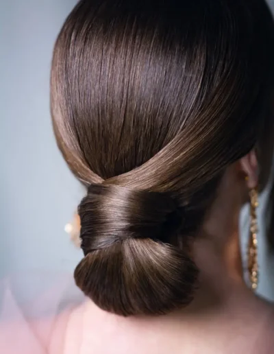 Sleek brunette low bun with smooth polished finish