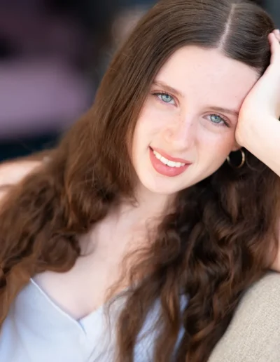 Teenage girl with long brown hair smiling during a portrait session