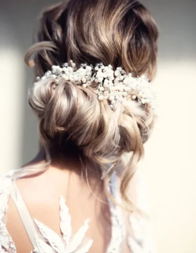 Textured bridal updo with pearl and floral hair accessory